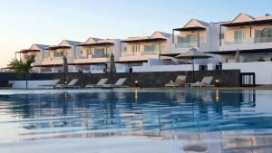 a swimming pool in front of some apartments at Serena del Mar by LIVVO in Playa Blanca