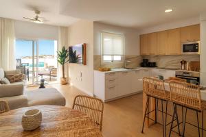 a kitchen and living room with a table and chairs at Serena del Mar by LIVVO in Playa Blanca