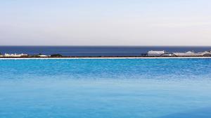 a large body of blue water with an island in the background at Serena del Mar by LIVVO in Playa Blanca