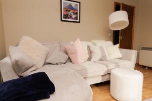 a living room with a white couch with pillows at The Sound Rest, Lerwick in Lerwick