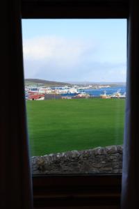 a window with a view of a green field at The Sound Rest, Lerwick in Lerwick