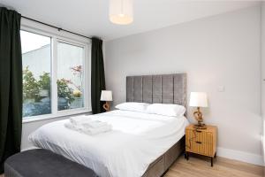 a bedroom with a large white bed with a window at New 2-Bed Home with Garden Near Google Dublin HQ & Train Station in Dublin