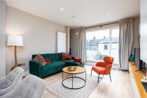 a living room with a green couch and orange chairs at New 2-Bed Home with Garden Near Google Dublin HQ & Train Station in Dublin +12 photos