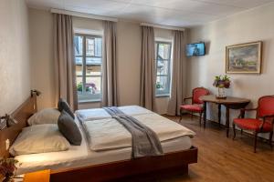 a bedroom with a bed and a table and chairs at Hotel Heintz in Vianden +56 photos