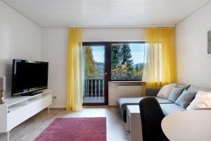 Una sala de estar con un sofá y una ventana grande. en Ferienwohnung Bergblick, en Triberg