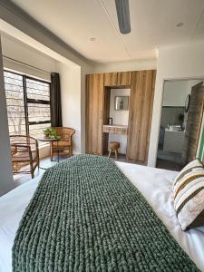 a bedroom with a large bed and a bathroom at Dung Beetle Bush Villa in Marloth Park