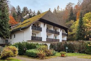 Un gran edificio blanco con balcón y árboles. en Ferienwohnung Bergblick, en Triberg