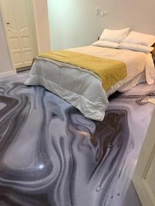 a bedroom with a bed with its reflection in the floor at Bendo house in Accra