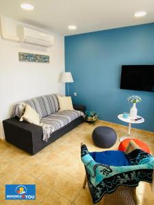 een woonkamer met een bank en een tv bij Appartamento Safir Son Bou con vista mare e piscina in Son Bou