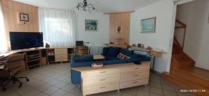 een woonkamer met een blauwe bank en een bureau bij Magyar Tenger Pihenőház, 4-8 főre Balatonakarattya in Balatonakarattya