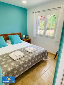 een slaapkamer met een bed met twee handdoeken erop bij Appartamento Safir Son Bou con vista mare e piscina in Son Bou