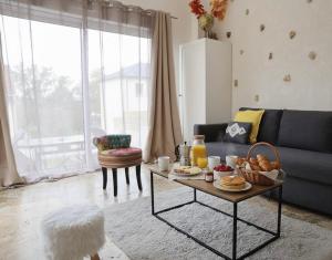 ein Wohnzimmer mit Sofa und Tisch mit Essen drauf in der Unterkunft Maison 4 pers 10 min Disneyland Paris Terrasse Parking Gratuit in Chalifert