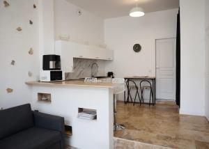 eine Küche und ein Wohnzimmer mit einem Sofa und einer Theke in der Unterkunft Maison 4 pers 10 min Disneyland Paris Terrasse Parking Gratuit in Chalifert + 2 Fotos