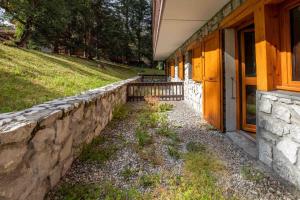 una pared de piedra junto a un edificio en La Forêt 15, en Méribel 4 fotos más