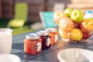 un comptoir avec des pots de confiture et un bol de pommes dans l'établissement Villa Paulina village heart near the beaches, à Portiragnes