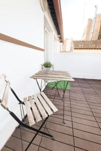 Una mesa de picnic y un banco en un balcón. en VTZ Hotel Plaza España, en Zaragoza