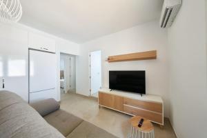 een woonkamer met een bank en een flatscreen-tv bij Eryan II in San José