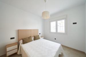 een witte slaapkamer met een bed en een raam bij Eryan II in San José