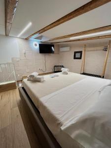 a large white bed in a room with a tv at Claustro Segreto - ALTAMURA in Altamura