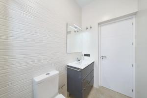 een witte badkamer met een toilet en een wastafel bij Eryan II in San José +9 foto's