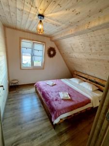 a bedroom with a large bed in a attic at GreenHeart-Măguri in Măguri-Răcătău