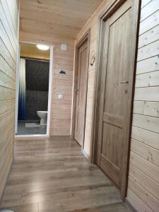 a hallway of a bathroom with a toilet and a door at GreenHeart-Măguri in Măguri-Răcătău