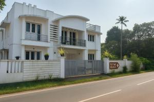 una casa blanca al costado de la carretera en Dream Nest Beach House, en Alleppey
