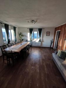 a dining room with a long table and chairs at GreenHeart-Măguri in Măguri-Răcătău