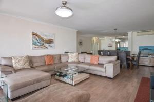 un soggiorno con un divano e un tavolo di Spacious Beach Access Apartment at Dolphin Beach a Bloubergstrand