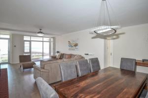 un soggiorno con un tavolo e un divano di Spacious Beach Access Apartment at Dolphin Beach a Bloubergstrand