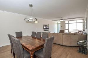 una sala da pranzo con un tavolo e un divano di Spacious Beach Access Apartment at Dolphin Beach a Bloubergstrand Altre 28 foto
