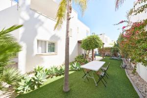 a garden with a table and chairs and palm trees at Villa Joya I in San José