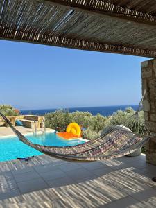 a hammock on a patio next to a pool at Onirozo Koroni Private Villa in Koroni