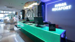 a lobby with a desk with a computer on it at Evenia Rocafort in Barcelona