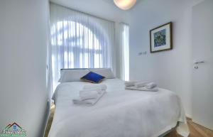 białe łóżko z ręcznikami w pokoju w obiekcie APT in Villa Bianca with Pool and air conditioning w mieście Lierna