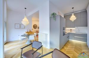 kuchnia i salon z krzesłami i stołem w obiekcie APT in Villa Bianca with Pool and air conditioning w mieście Lierna