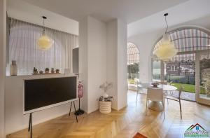 a living room with a television and a dining room at APT in Villa Bianca with Pool and air conditioning in Lierna