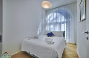 sypialnia z białym łóżkiem i ręcznikami na nim w obiekcie APT in Villa Bianca with Pool and air conditioning w mieście Lierna +16 zdjęć
