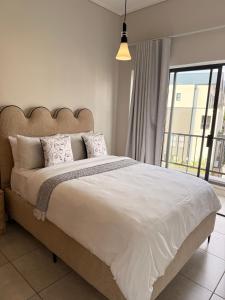 a bedroom with a large bed and a large window at Luxury lagoon at Munyaka in Midrand