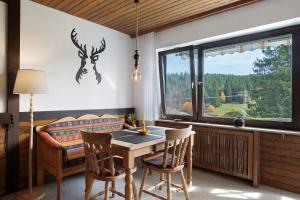 een eetkamer met een tafel en een raam bij Appartment Auszeit in Schönwald