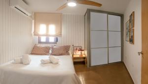 una camera da letto con un grande letto bianco con due cuscini di Habana en el corazón de Cuenca a Cuenca