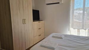 a bedroom with a bed and a dresser with a television at Maisonnette du Foirail in Espalion