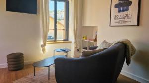 a living room with a couch and a window at Maisonnette du Foirail in Espalion