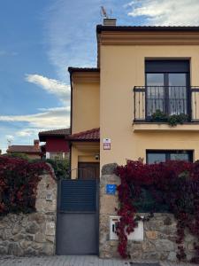 a house with a black door and flowers on it at Mirador de Peña La Estrella in Ortigosa del Monte