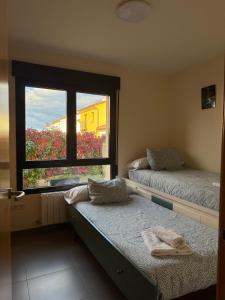 two beds in a room with a window at Mirador de Peña La Estrella in Ortigosa del Monte