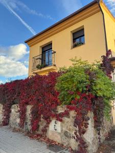 a building with a wall covered in red flowers at Mirador de Peña La Estrella in Ortigosa del Monte
