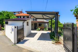 a house with a gate and a garage at Kuća za odmor Miha in Tar