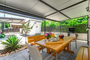 an outdoor patio with a wooden table and chairs at Kuća za odmor Miha in Tar