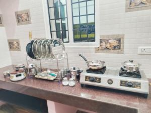 a kitchen counter with a stove and pots and pans at Miracle Stay in Madurai