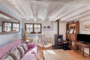 Una sala de estar con un sofá y una estufa de leña. en Brugarolas Village, en Castelltersol